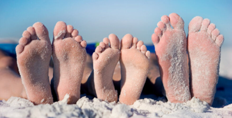 family feet at the beach