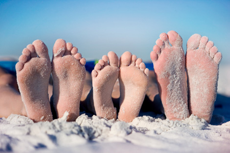 family feet at the beach